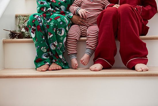 Christmas traditions, children sitting on a step in Christmas pajamas